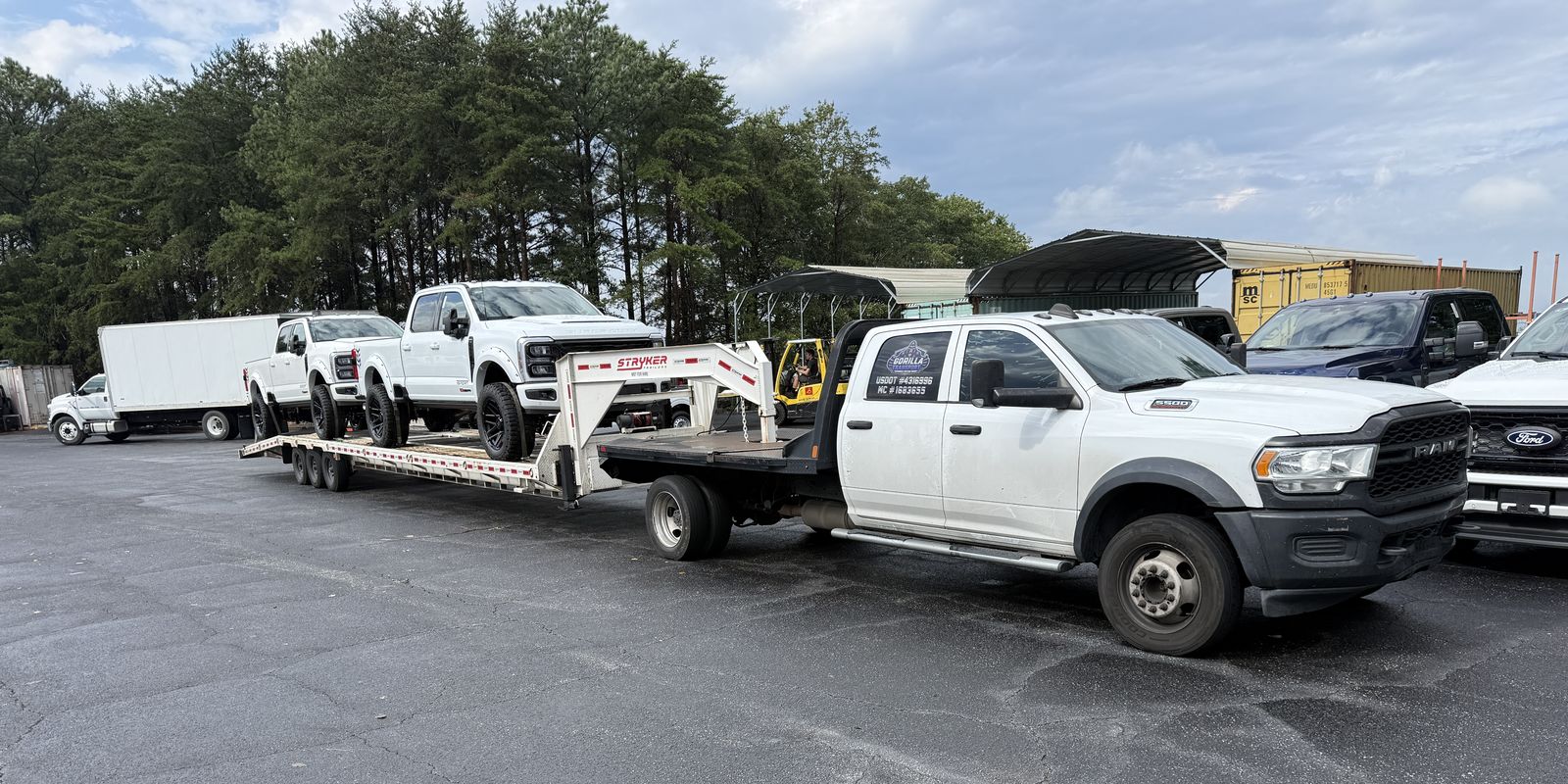 Gorilla Transport white Ram dually pulling a Stryker gooseneck car trailer loaded with two white Ford Super Duty trucks